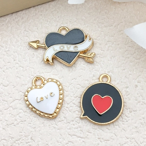 Macro view of gold enamel heart pendants with LOVE engraving on beige fabric