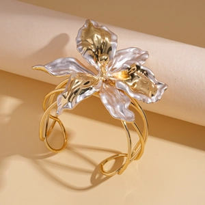 Detailed view of large gold and silver layered flower cuff bracelet with hollow bands