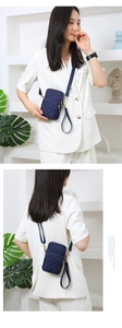 Quilted nylon crossbody phone bag in navy blue with multi-zipper layers and straps