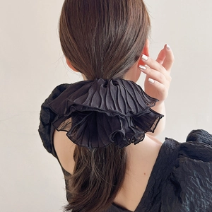 Elegant oversized black pleated scrunchie in soft chiffon fabric shown on hair
