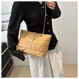 Close-up of khaki quilted faux leather shoulder bag with metal chain strap and lock