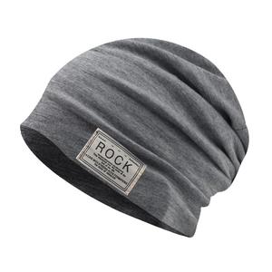 Dettaglio ravvicinato di un berretto in cotone grigio con patch 'ROCK' ricamata