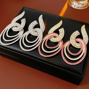 Detailed view of silver and gold geometric drop earrings with sparkling rhinestones on display