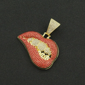 Detailed view of a gold-plated necklace pendant with red lips and diamond-set teeth