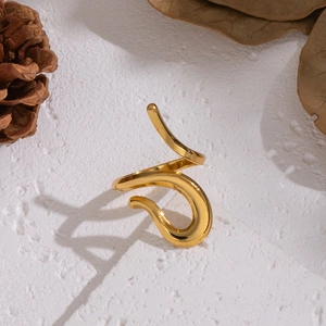 Minimalist gold wavy open ring with high-gloss metallic finish on natural textured surface