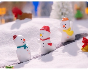 Close-up of miniature resin snowmen with colorful hats for Christmas DIY decor