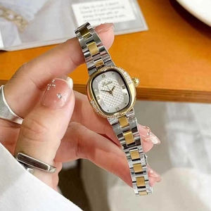 Elegant two-tone oval watch with rhinestone bezel worn on wrist for female fashion style