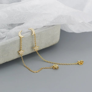 Detail of s925 silver gold star and moon tassel earrings with sparkling crystals