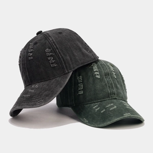 Distressed washed denim baseball caps with ripped holes and vintage streetwear aesthetic