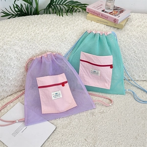 Détail de sacs à dos en maille à cordon en couleurs contrastées violet et bleu