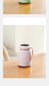 Macro shot of peach pink insulated mini cup with black lid and silicone carry loop