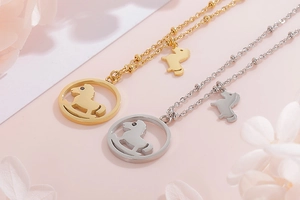 Détail des pendentifs cheval à bascule dorés et argentés sur colliers en acier
