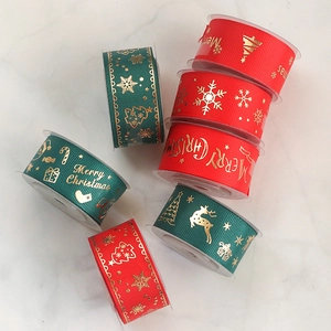 Detail of red and green ribbed Christmas ribbons with gold foil Merry Christmas prints