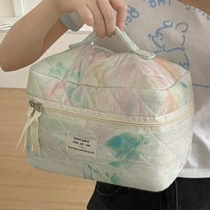 Quilted watercolor tie-dye makeup bag with dual zippers and elegant ribbon handle