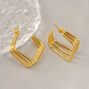 Three-layer square gold earrings in 18k gold plated stainless steel on grey fabric