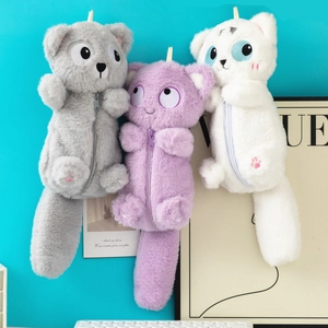 Gros plan de trousses chat en peluche avec queues douces et détails brodés fins