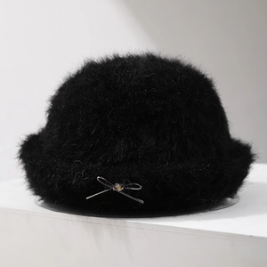 Close-up of black plush bucket hat featuring a delicate metal bow and beaded detail