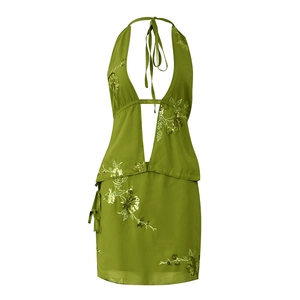 Detail of green halter neck top and mini skirt with floral embroidery and sequins