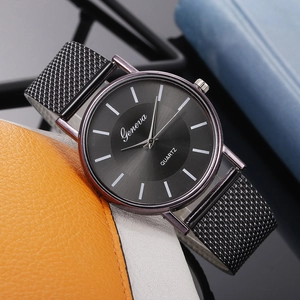 Close-up of Geneva minimalist quartz watch with black mesh band on a leather surface