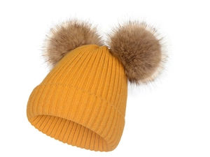 Détail du bonnet en tricot jaune à côtes avec deux pompons en fausse fourrure marron