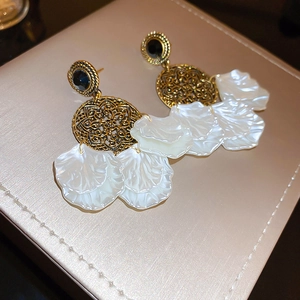 Vintage gold hollow floral earrings with white petal pendants and black gemstone studs