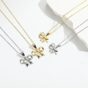 Minimalist gold and silver bow necklaces in small and large sizes on a clean white background