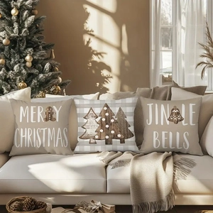 Three-piece linen Christmas pillow covers with ginger man and bell prints on a sofa