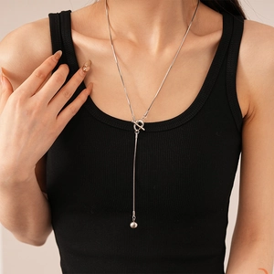 Close-up of minimalist silver OT toggle long sweater necklace with spherical pendant detail