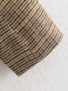 Detail von gewebtem Hahnentrittmuster und Ärmelsaum am herbstlichen Freizeitblazer