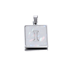 Macro detail of square stainless steel letter I pendant with white shell inlay