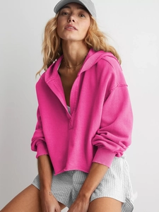 Detailansicht des offenen Saums und der Rippbündchen am magentafarbenen Hoodie