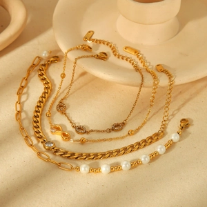 Five assorted 18k gold plated stainless steel bracelets with pearls and charms