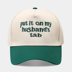 Detail der grünen Stickerei auf einer creme- und waldgrünen Trucker-Cap mit Text