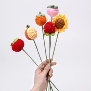 Handgehäkelter Blumenstrauß mit gestricktem Apfel, Erdbeere und Sonnenblume auf Weiß