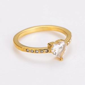 Detail of gold heart ring featuring a large clear zircon and side accent diamonds