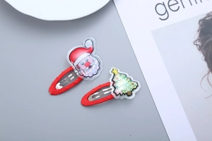 Detail of Christmas tree and Santa Claus hair clips with red glitter quicksand inside