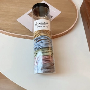 Macro view of colorful elastic hair bands packed in a transparent cylinder container