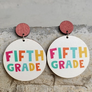 Macro detail of wooden Fifth Grade teacher earrings with colorful lettering and steel pins