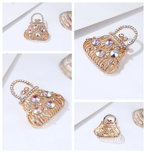 Detailed view of handbag-shaped brooch with gold plating and sparkling crystals