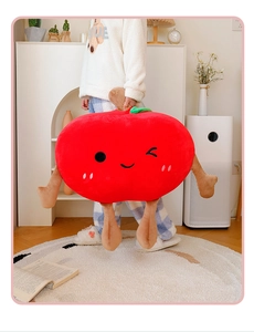 Detail of red apple plush pillow with cute embroidery and soft texture in a cozy home setting