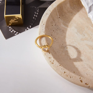 Dettaglio macro dell'anello a cuore in zircone oro 18 carati su un vassoio in pietra
