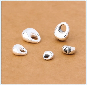 Macro shot of assorted S925 sterling silver pebble pendants with Fu character engraving