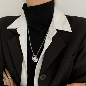 Close-up of hip-hop silver double ring pendant necklace with textured detail on model