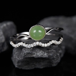 Macro view of S925 sterling silver ring set with natural green gemstone on black stones