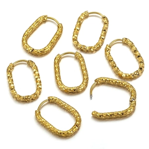 Set of 7 gold oval earrings with diamond-cut texture and snap closure on white background