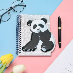Close-up of spiral notebook featuring 3D panda cover and silver glitter finish