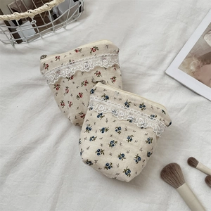 Close-up of floral fabric pouches with lace trim and zipper for cosmetic storage