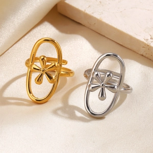 Minimalist geometric gold and silver floral oval rings on a textured beige backdrop