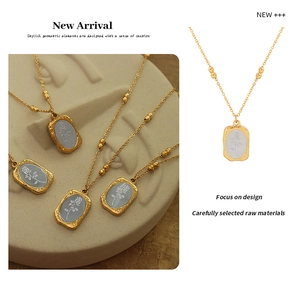 Detail of 18K gold plated steel necklaces with rose pattern on geometric pendants