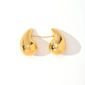 Detailed close-up of chunky gold teardrop earrings with a polished metallic finish